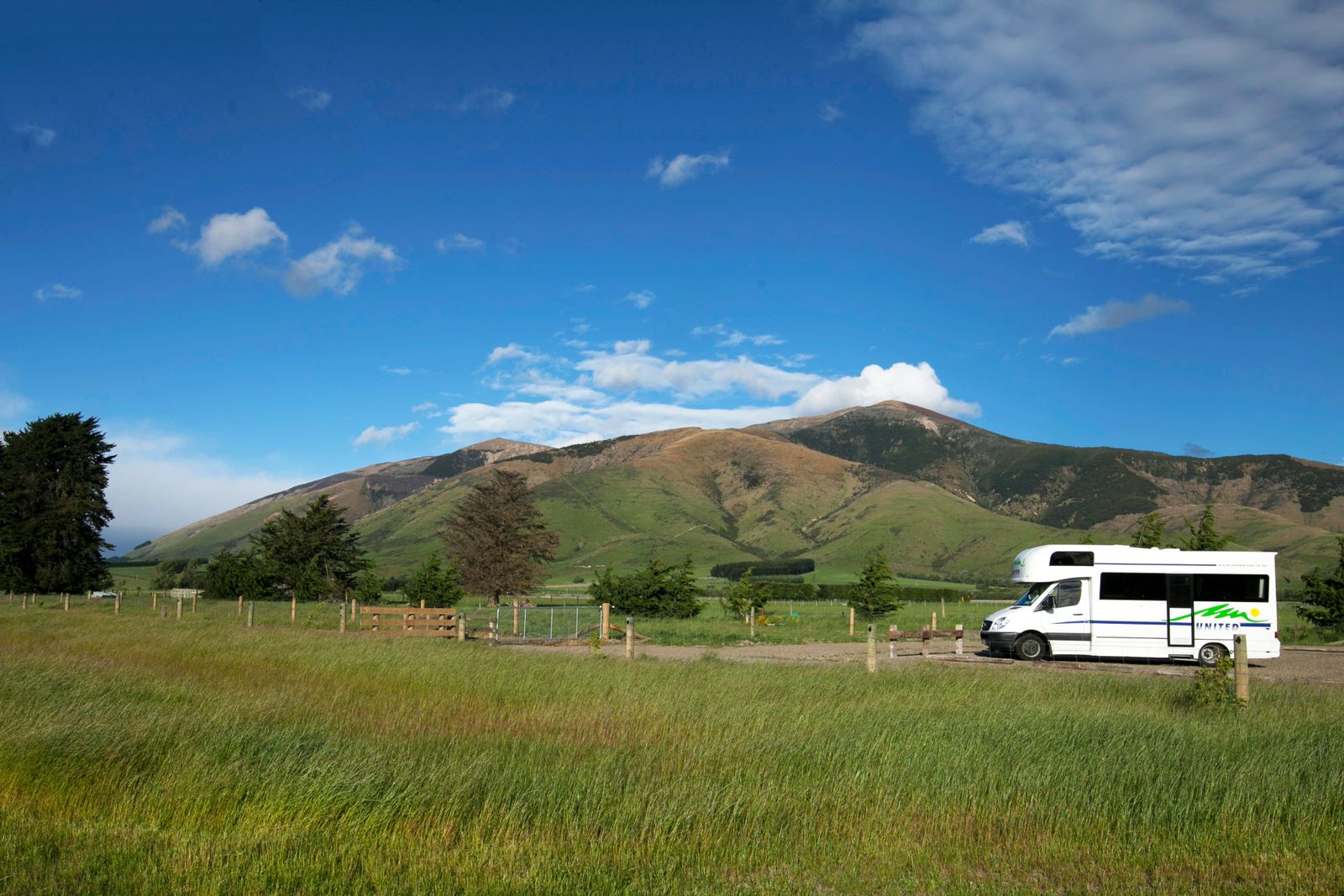 Gewone witte camper geparkeerd op een grasveld, voorbeeld van een camper voor recreatief gebruik